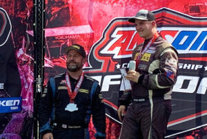 two racecar drivers with medals around their necks