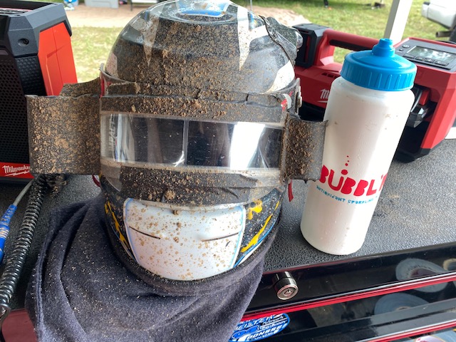Bubbl'r bottle sits next to a muddy race helmet