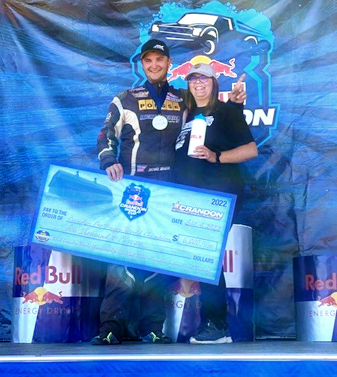 Mike Meister stands with a woman holding an oversized check after winning the Pro Buggy 2022 Crandon World Championship