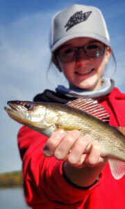 2022_FishingWinner_6_vert Closeup photo of a the Winner of the Take a Kid Fishing Contest holds up a fish that she caught