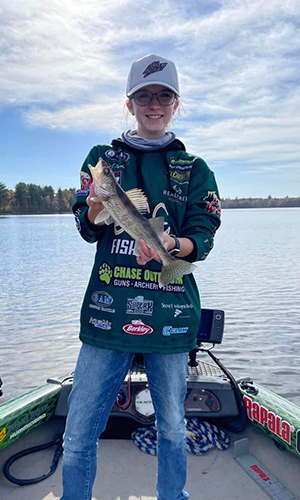 Winner of Take a Kid Fishing Contest holds up a fish that she caught