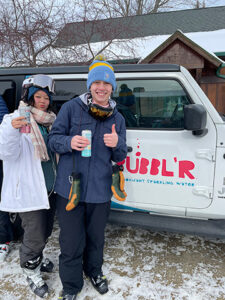 Granite-Peak-Bubblr-Tasting-9 Granite Peak Bubblr Tasting holding cans in front of Jeep