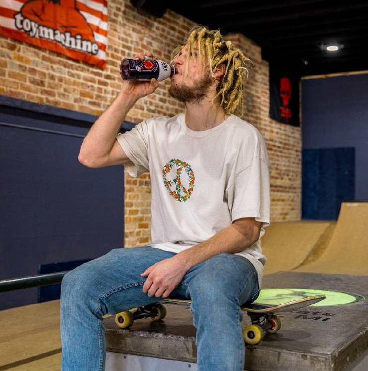 skateboarder drinking a bottle of Shine