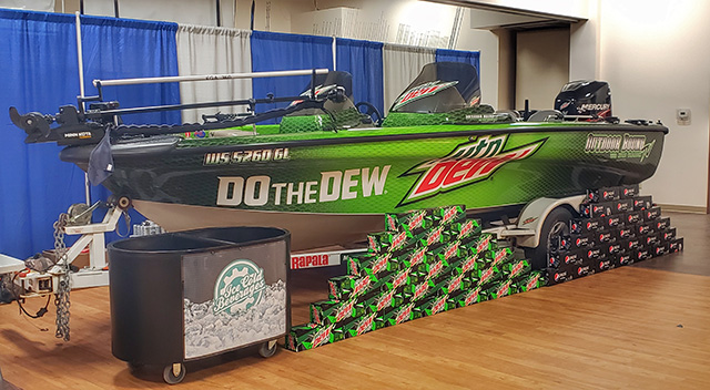 Mountain Dew sponsored fishing boat with Mountain Dew and Pepsi 12 packs piled up