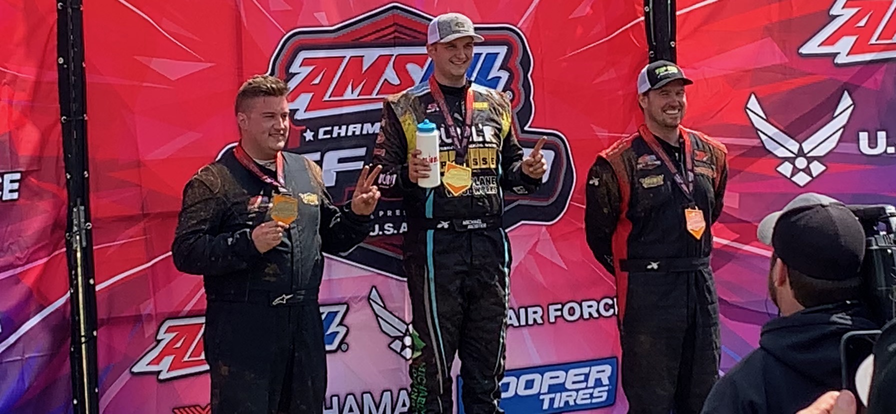 Michael Meister wins first place, and stands on the winners podium with 2nd and 3rd place finishers