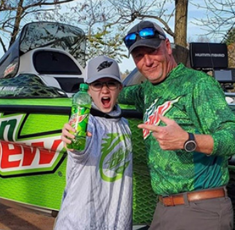 careers-grid-Mtd-Dew-Take-Kid-Fishing girl with Mtn Dew bottle and fishing guide in front of Mountain Dew boat