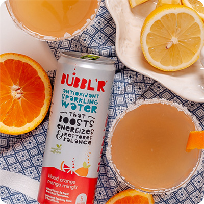 a can of blood orange mango mingl'r Bubbl'r next to a mixed sidecar drink in a glass